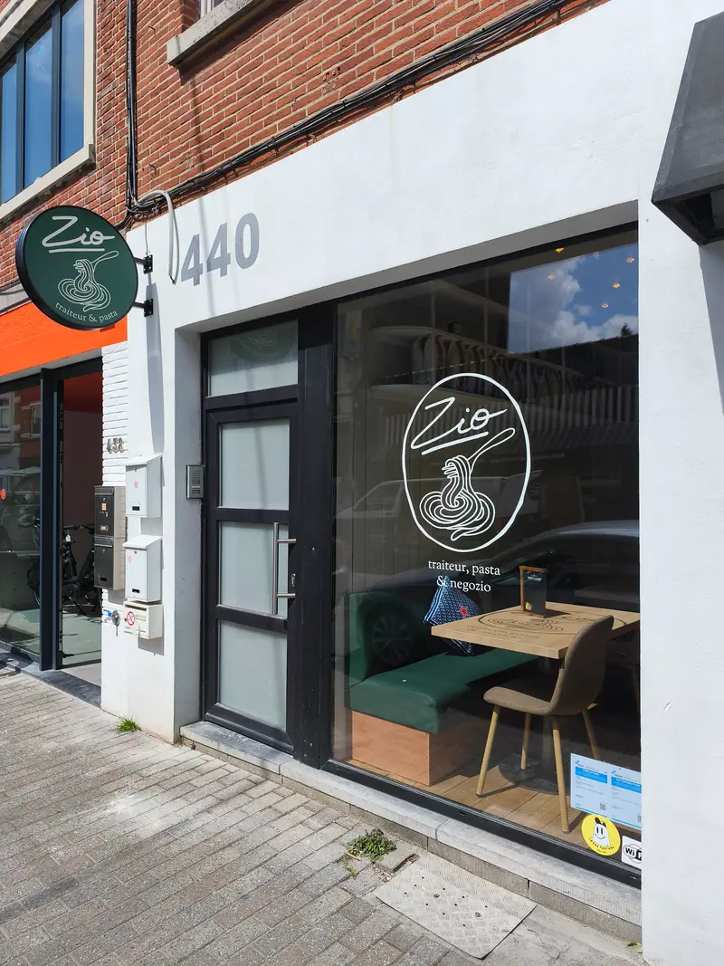 Vitrine du restaurant Zio avec logo en vitrophanie et enseigne drapeau